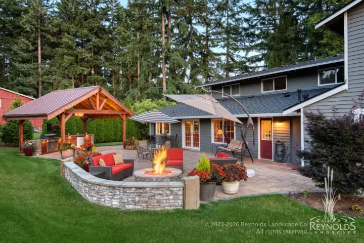 large, multi-room patio with fire pit, conversation area with seat-wall, large, covered outdoor kitchen, and dining area