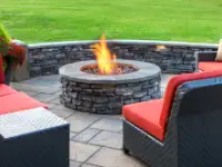 Gas fire pit on natural stone paver patio.