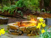 Natural, montana ledgestone wood fire pit on random flagstone with boulder benches.