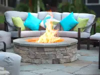 Beautiful, natural stone fire pit set on natural flagstone pavers.