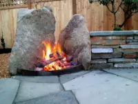 Unique, boulder wood fire pit seatwall end cap.