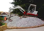 backhoe sitting on gravel pile