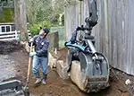 backhoe installing boulder