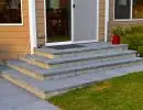 Bluestone tread front entry steps with a wide landing and concrete block base at a residential home