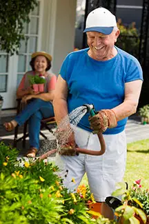 senior watering flowers
